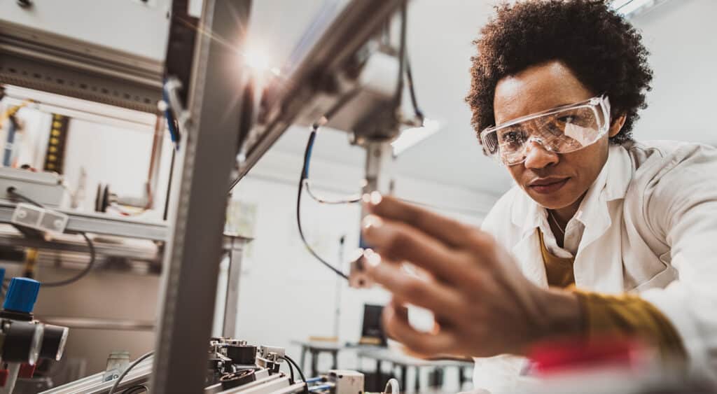 Woman wearing safety glasses working on machine