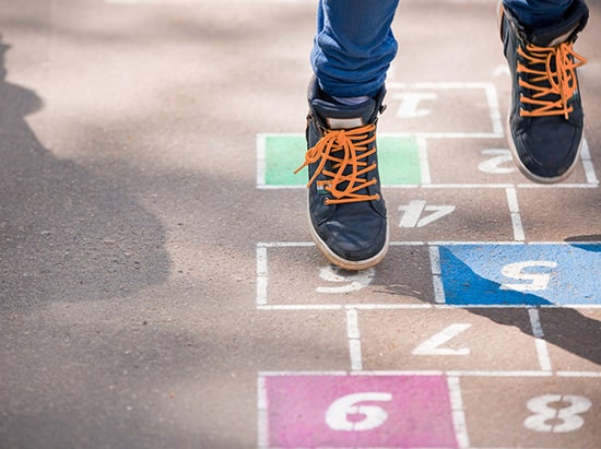 child-playing-hopscotch-on-pavement-sub-teacher