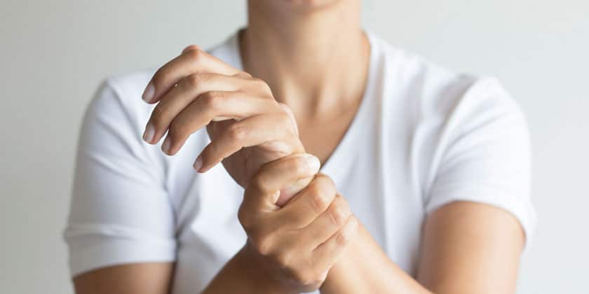 Person holding their wrist