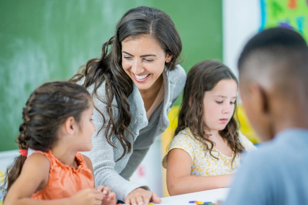 teacher helping student at desk